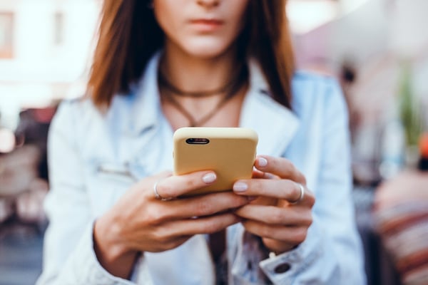 young-beautiful-girl-uses-smartphone-street-surfing-internet